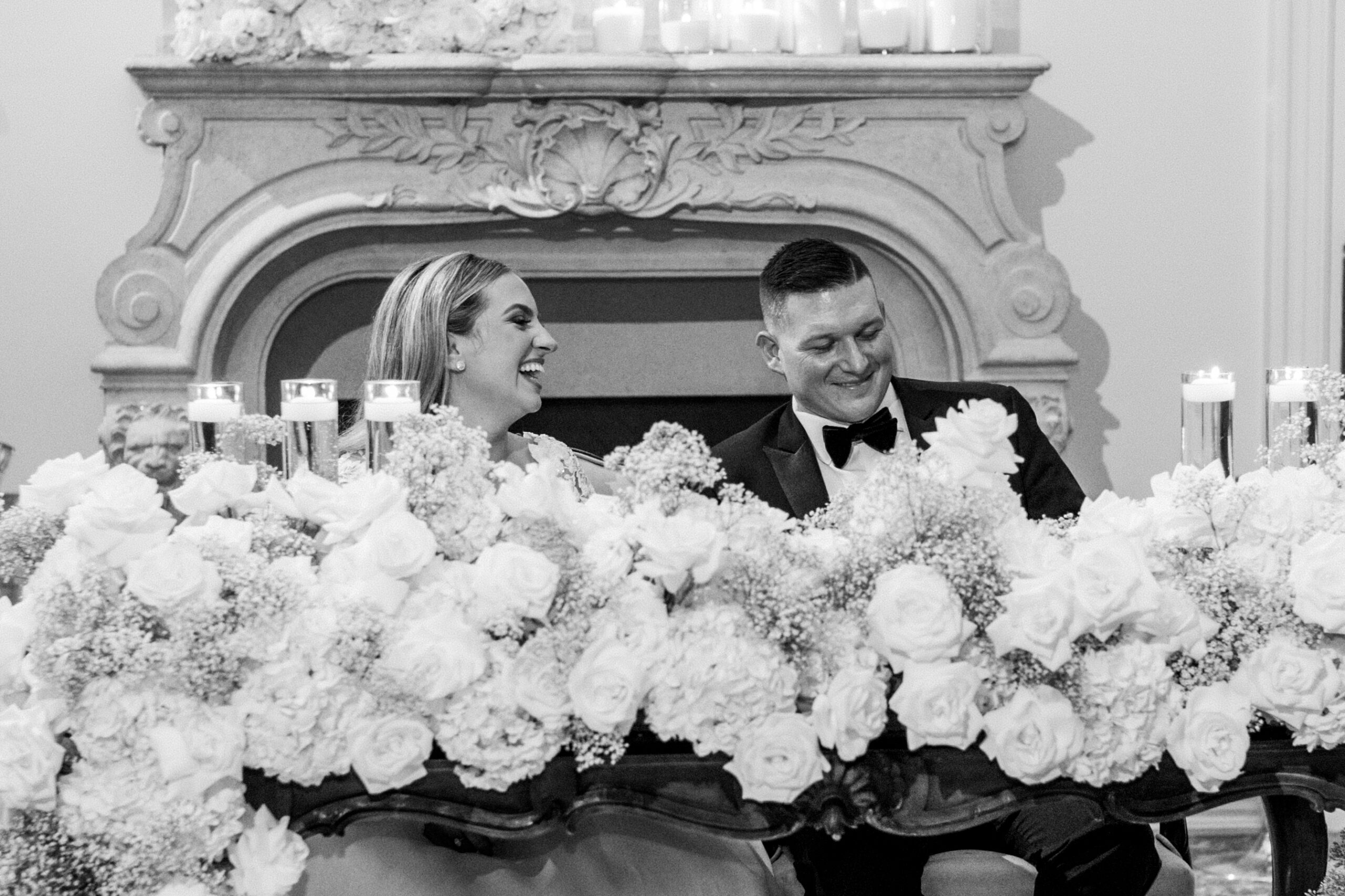 Timeless Park Chateau Wedding by Destination Film Wedding Photographer Katie Trauffer bride and groom laugh at flower covered table