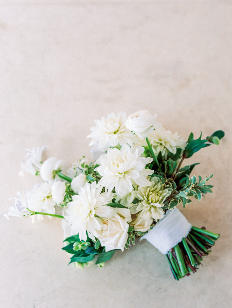 lush luxury neutral bouquet photographed on cream stone at Modern Coastal Waterfront Wedding