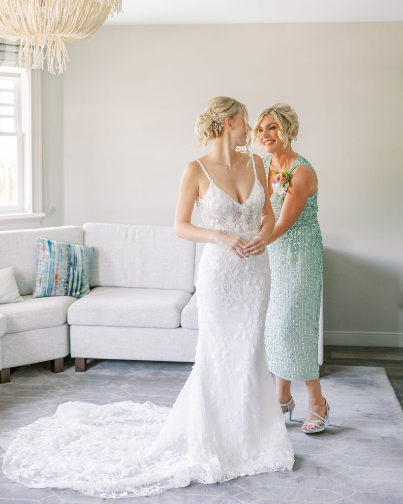 bride in lace gown gets ready with her mother