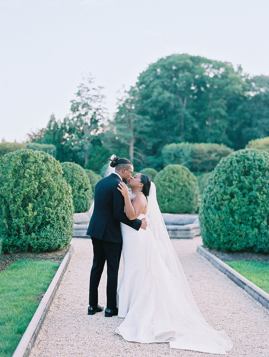 bride and groom kiss in oheka castle garden wedding