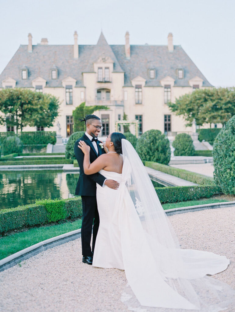 bride and groom stand in garden Oheka Castle Wedding Photography